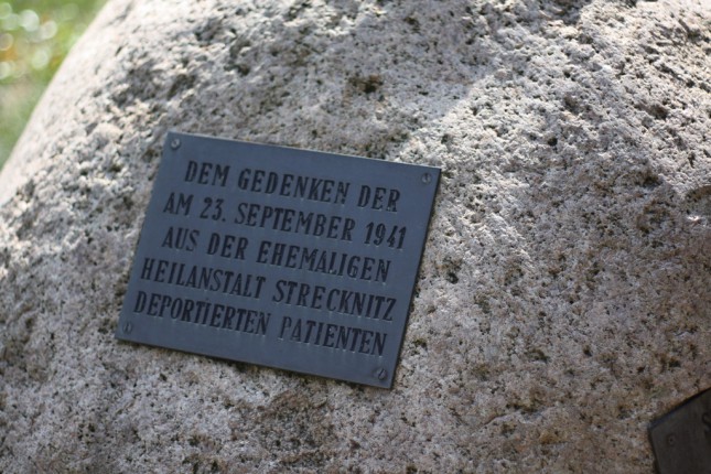 Die Inschrift des 1983 aufgestellten Gedenksteines erinnert an die deportierten Patienten.